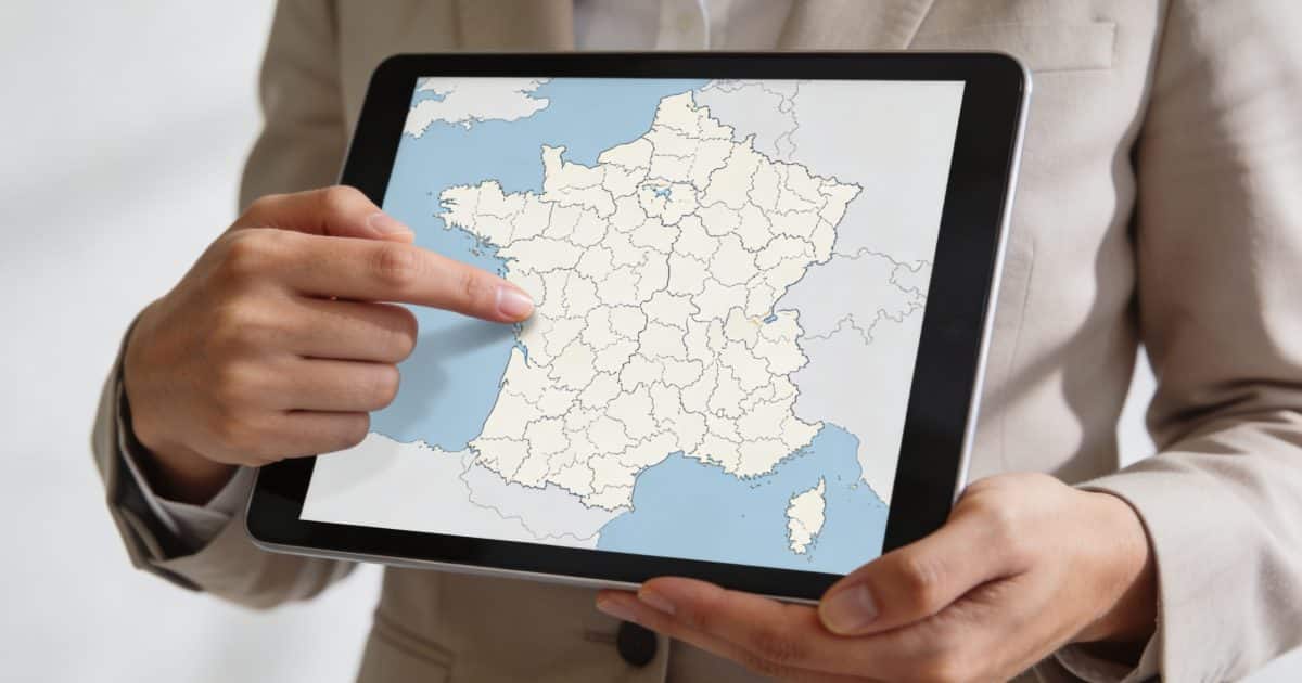 agent immobilier montrant carte de France sur tablette