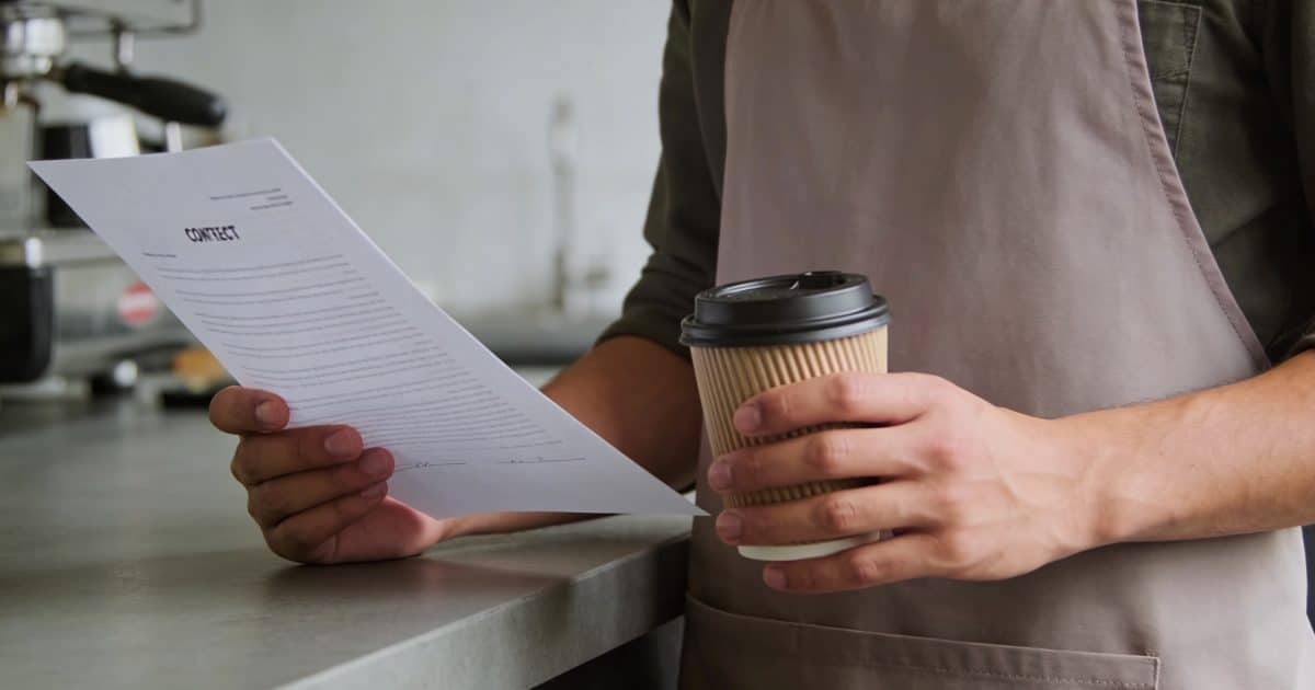Barista verse du cafe en regardant un contrat