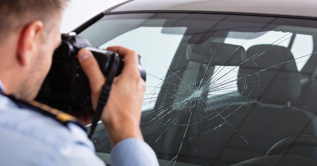conducteur photographiant pare brise fissure voiture assureur
