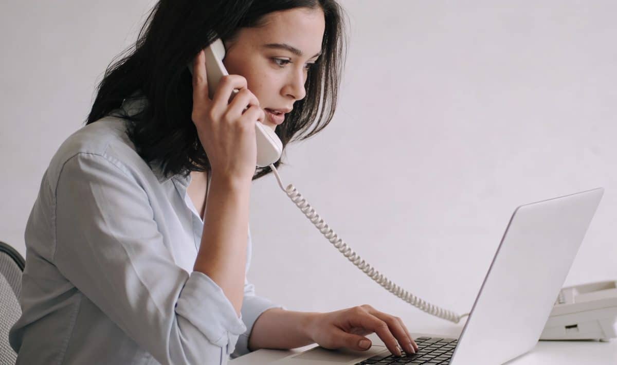 femme assise au telephone devant ordinateur brandt
