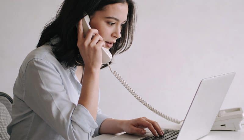 femme assise au telephone devant ordinateur brandt