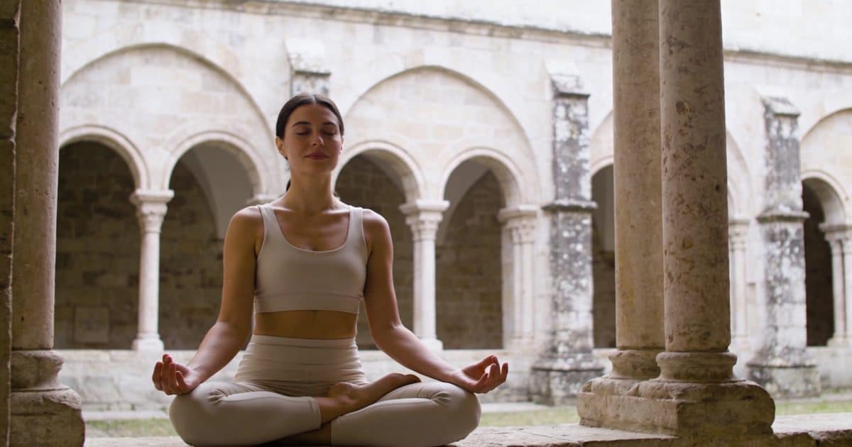 femme assise en meditation dans cloître ancien