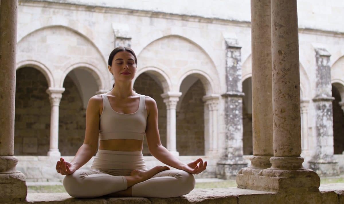 femme assise en meditation dans cloître ancien