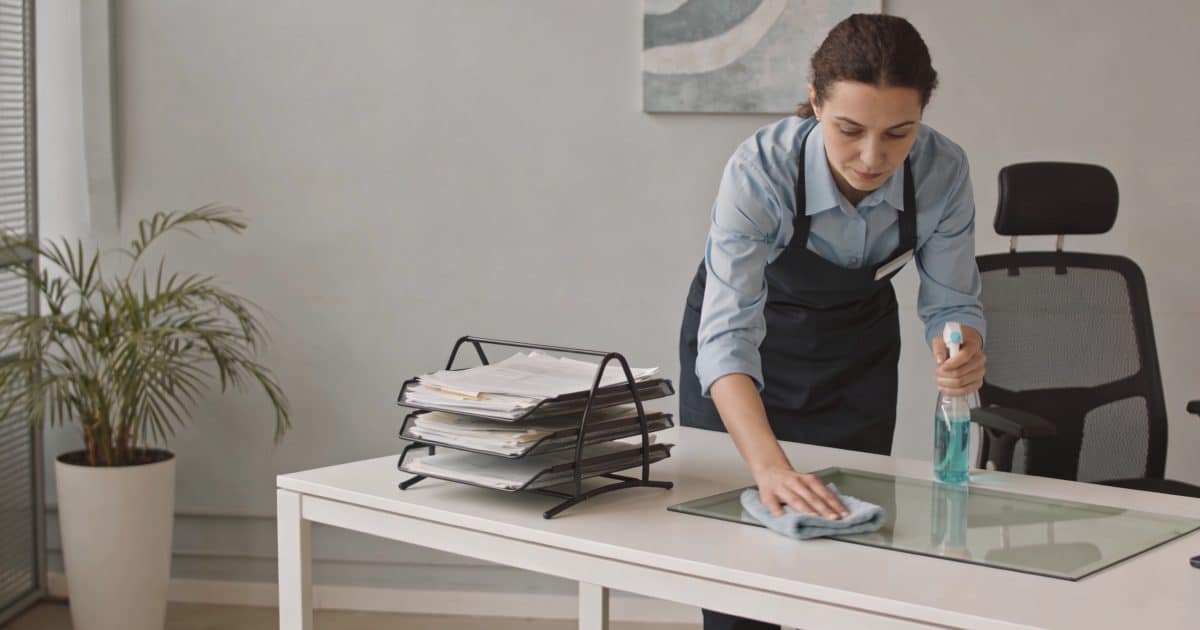 Femme de menage nettoyant un bureau moderne