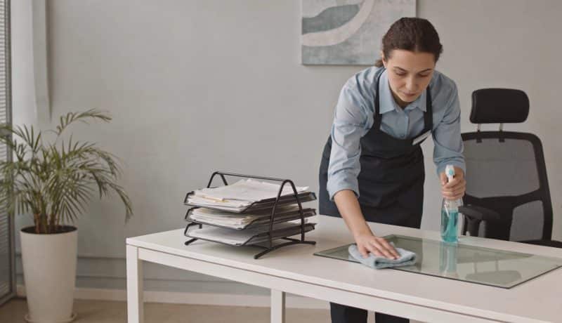Femme de menage nettoyant un bureau moderne