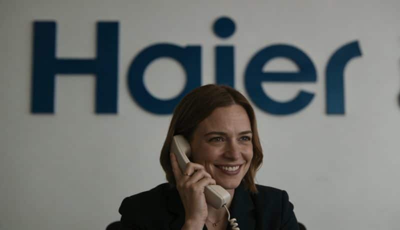 femme souriante au telephone devant logo haier