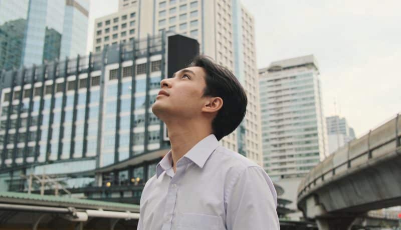 Jeune homme en chemise observent gratte ciel de Bangkok