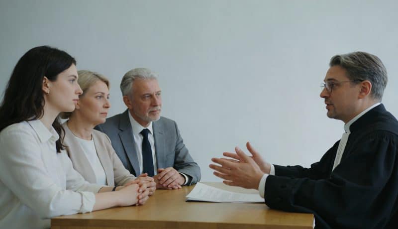 Notaire assis expliquant un testament a une famille